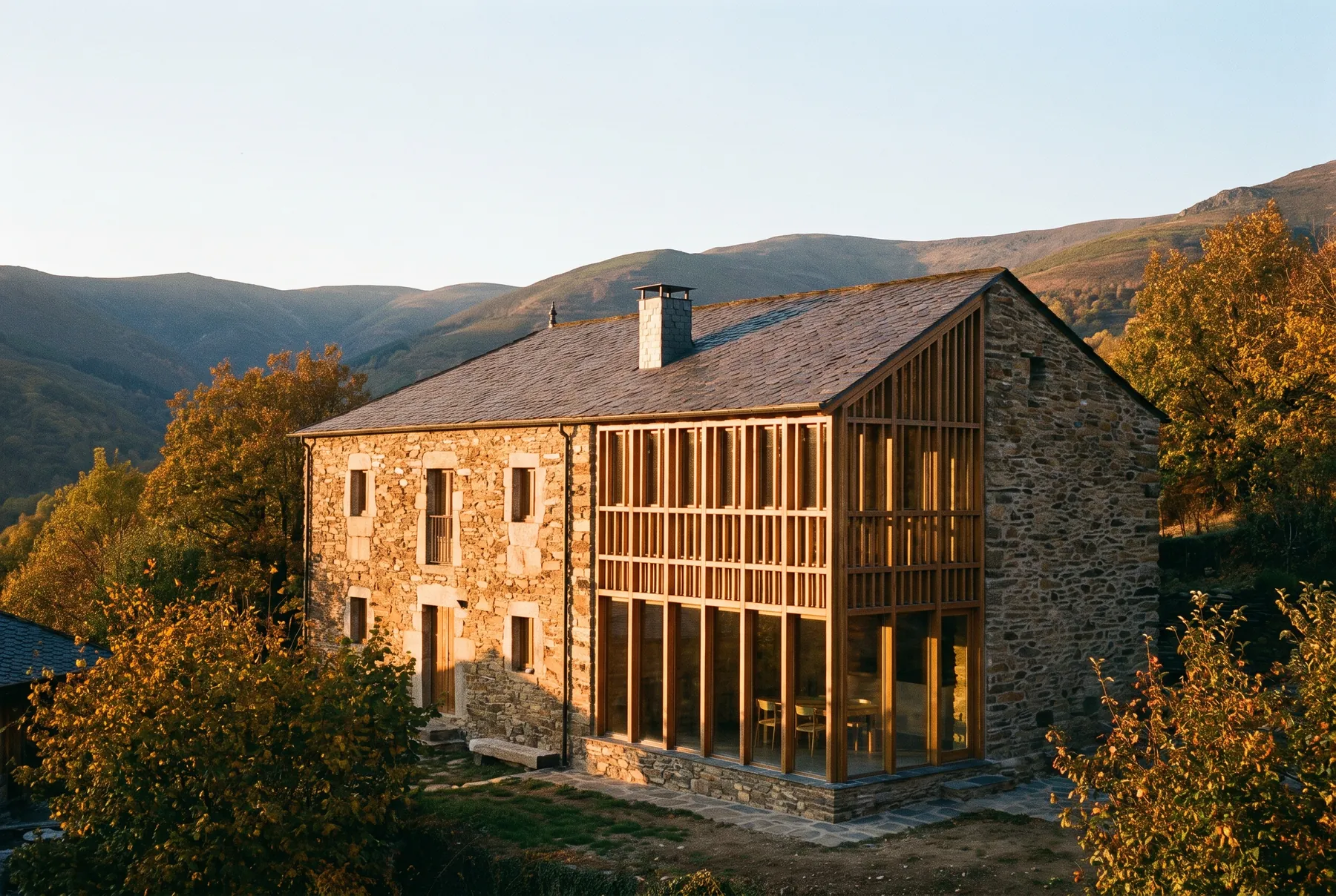 Casa de piedra rehabilitada con ampliación de madera y vidrio