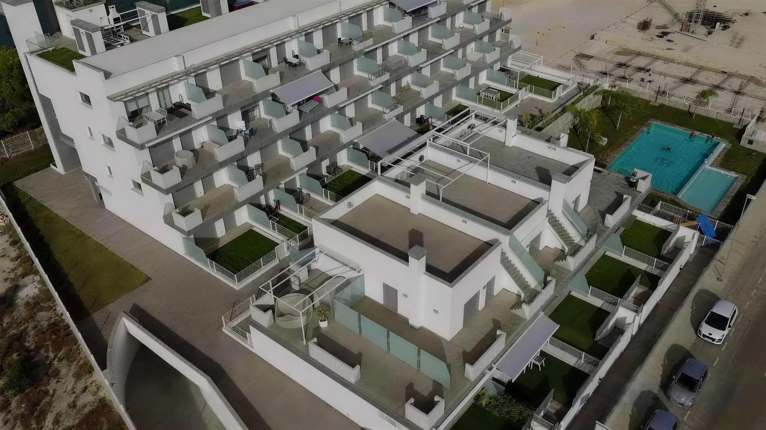 Vista aérea de un complejo residencial con piscina construido por Nistal y Bello